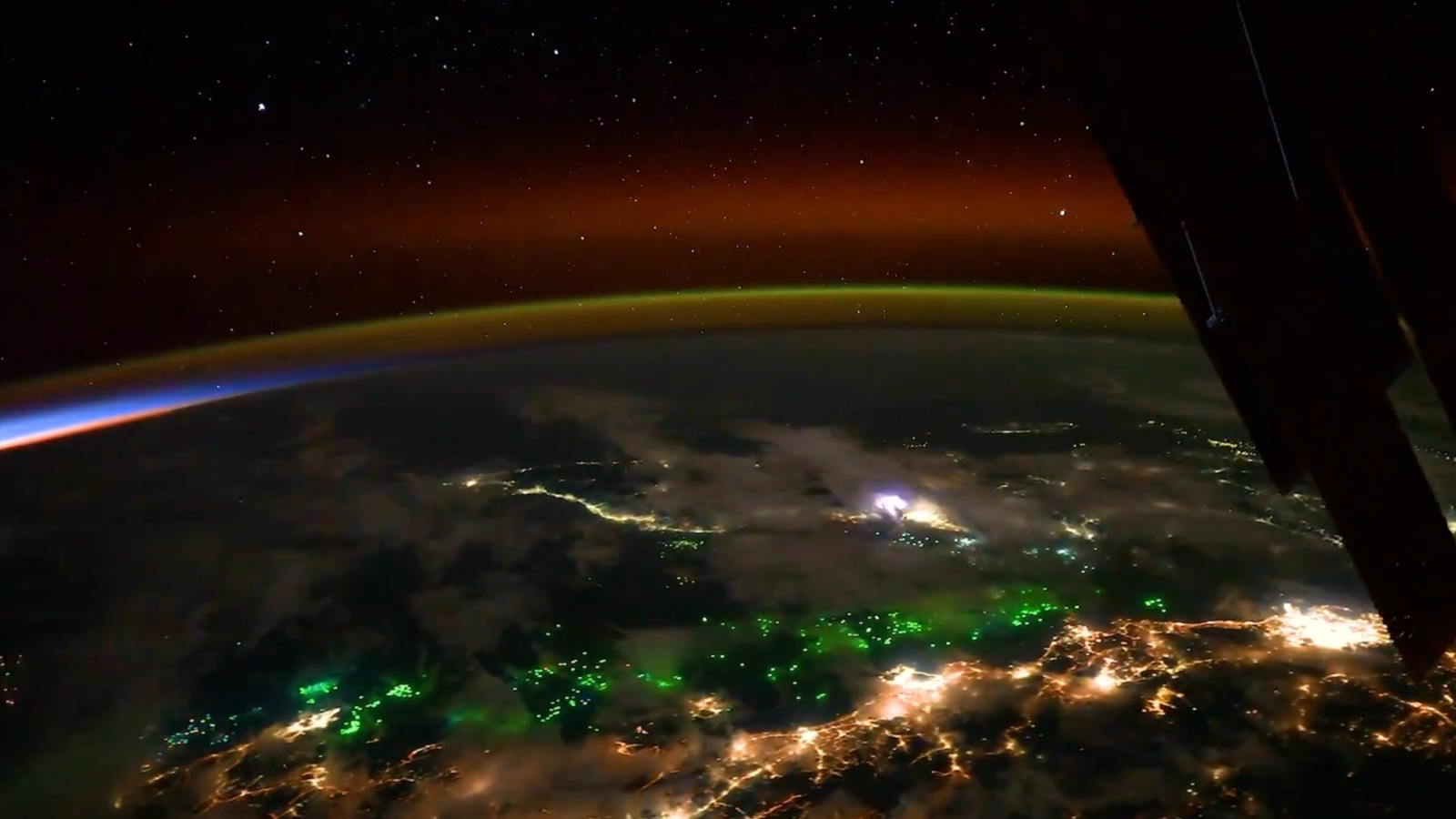 lines of green, red and gold over a dark surface